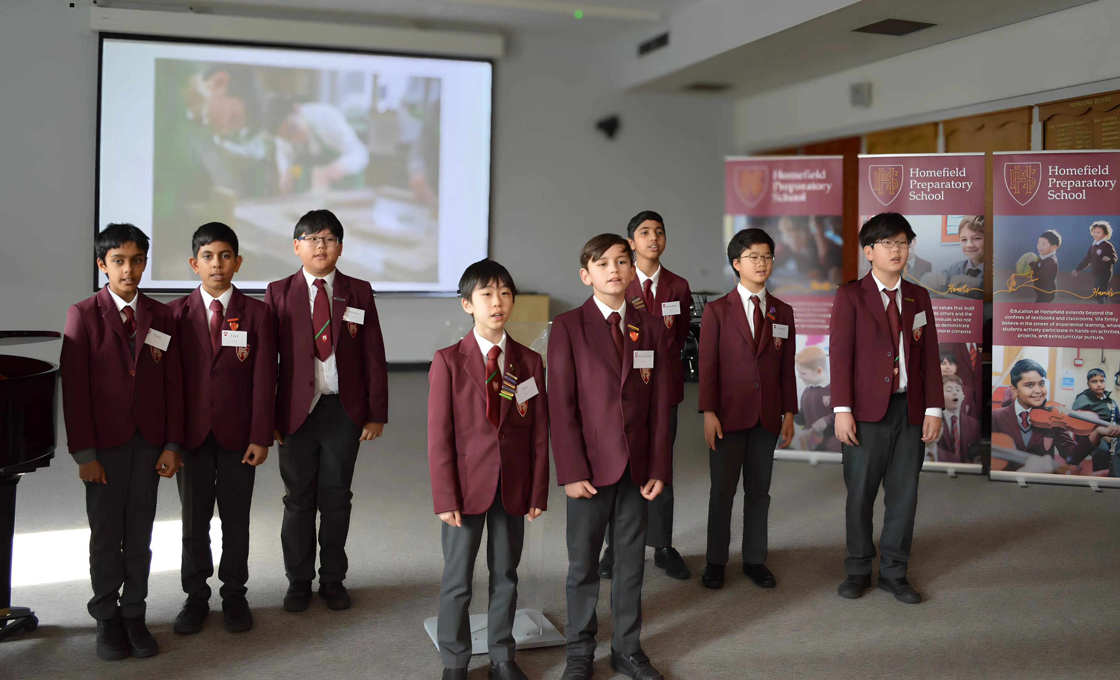 Boys giving a presentation to their peers in performance hall at Homefield Prep