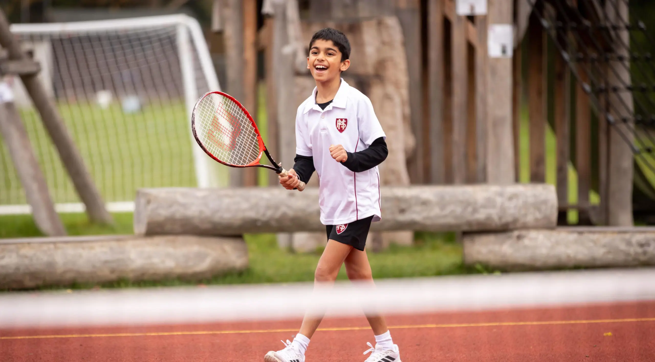 Student playing tennis on the playground at Homefield Prep